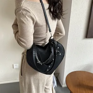 Black heart-shaped leather crossbody bag with silver studs and chain straps for women