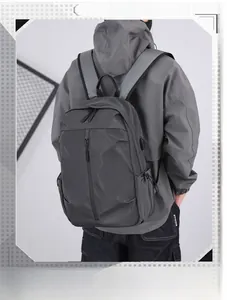 Detail of dark grey backpack featuring a built-in USB charging port and water-resistant fabric