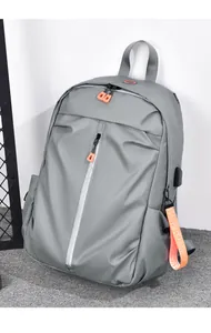 Détail macro d'un sac à dos gris avec fermeture orange et port de chargement USB extérieur