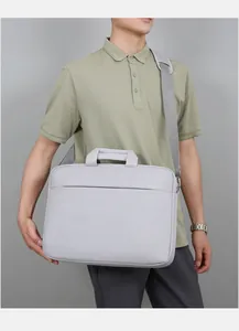Détail d'une sacoche grise pour ordinateur avec bandoulière réglable et logo fashion