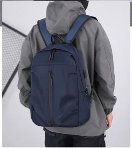 Detail showing the USB charging port and adjustable drawstring side pocket on the blue backpack
