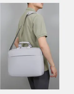Sacoche d'ordinateur gris clair minimaliste avec bandoulière portée par un mannequin