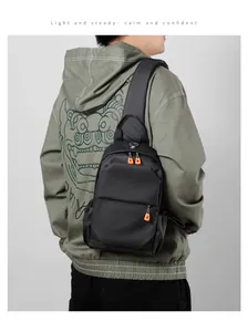 Black Oxford fabric crossbody chest bag for men with vibrant orange zipper details