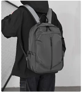 Detail of dark grey waterproof nylon backpack showing front zip pocket and side mesh pocket