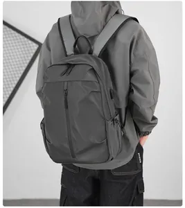 Detail of dark grey backpack featuring a built-in USB charging port and side pocket