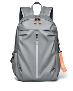 Détail d'un sac à dos de voyage gris avec accents orange et port de charge USB externe