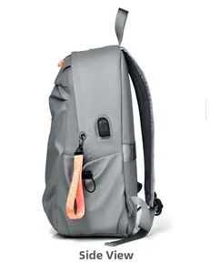 Détail du sac à dos gris avec port de charge USB et accents orange sur le côté de l'article
