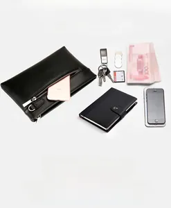 Detailed view of spacious interior of black leather men clutch bag with daily essentials
