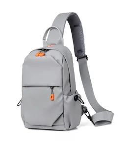 Detail of grey oxford chest bag showing orange zipper puller and side drawstring pocket