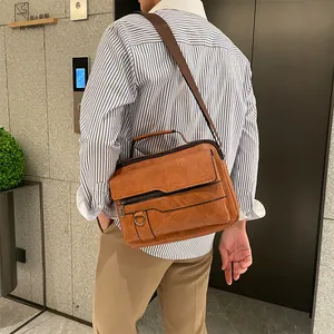 Detail view of a vintage brown leather men's briefcase with multiple zipper pockets