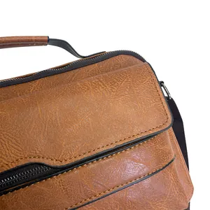 Close-up of brown textured leather business briefcase with handle and stitching details