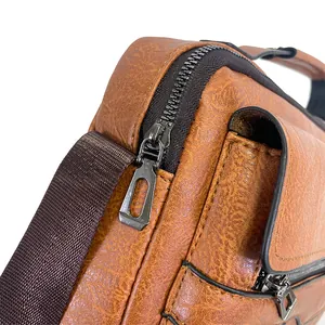 Close-up of caramel brown pebble grain leather briefcase with metallic zipper detail