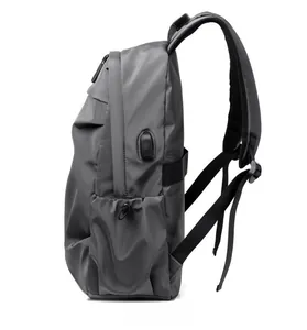 Detail view of dark grey backpack side with integrated USB charging port and side pocket