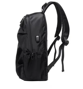 Detail view of the black backpack featuring a side USB charging port and mesh pocket