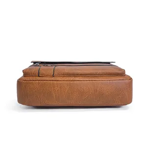 Detail view of brown textured leather business bag side stitching and multi-layer design
