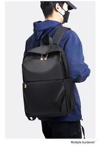 Gros plan du sac à dos noir avec tissu imperméable et détails de fermeture éclair orange vif