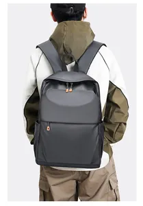 Détail d'un sac à dos d'affaires gris foncé avec zips orange et poche latérale gourde