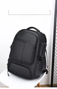Détail d'un sac à dos noir imperméable avec de nombreuses poches zippées sur une chaise