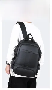 Vue arrière d'un homme portant un grand sac à dos noir imperméable pour ordinateur