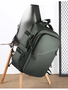 Detail of olive green waterproof matte nylon backpack showing multi-pocket layered design