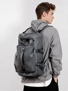 Side view of gray waterproof travel backpack on model showing large capacity and buckles