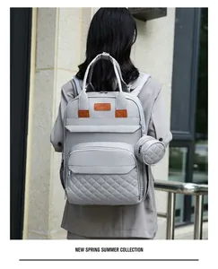 Détail du sac à dos langer gris avec matelassage en losanges et petite pochette ronde