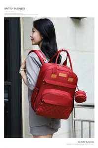 Gros plan du sac à dos rouge multifonctionnel avec motif matelassé et petit porte-monnaie