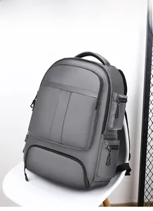 Vue détaillée du sac à dos gris en nylon imperméable sur une chaise montrant le tissu et poches