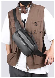 Close-up of a charcoal grey crossbody bag with adjustable strap on a male model