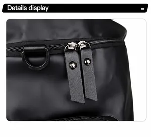 Detail of durable dual zippers with leather pullers and D-ring on black waterproof travel bag