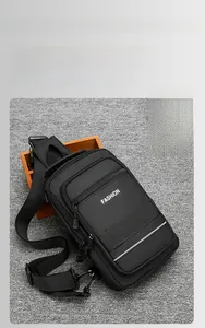 Macro shot of black multi-compartment crossbody bag with grey reflective safety stripe