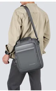 Men's dark gray water-resistant messenger bag showing crossbody fit and fabric detail