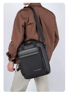 Close-up of a black waterproof business messenger bag worn by a model in a casual outfit