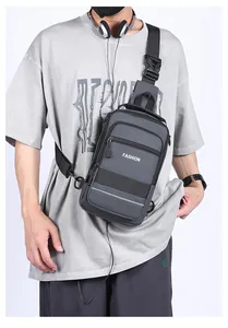 Detail of grey men's crossbody bag with reflective strip and functional zipper pockets