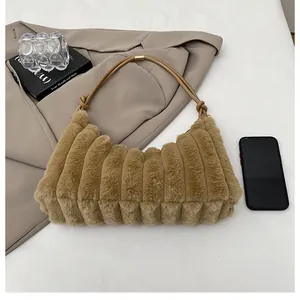 Gros plan d'un sac en peluche marron avec texture ondulée et bandoulière à nœuds