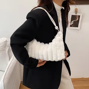 Sac hobo moderne en fausse fourrure blanche avec matelassage rayé dans un décor épuré