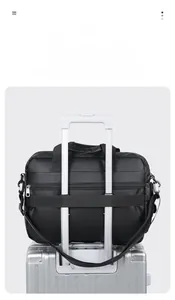 Waterproof laptop bag with back strap secured to a silver trolley suitcase handle