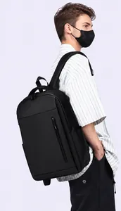 Side view of matte black travel backpack on model showing padded shoulder straps
