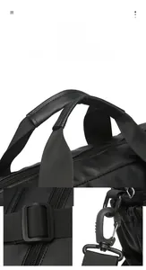 Detailed macro view of durable reinforced handles and adjustable buckles on a black laptop bag