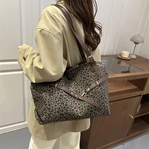 Sac fourre-tout à imprimé léopard avec bandoulière en cuir marron porté par un mannequin