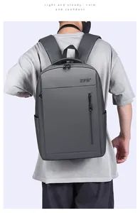 Rear view of a man carrying the dark grey waterproof laptop backpack with brand logo