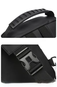 Detail of reinforced rubber handle and durable plastic buckle on black crossbody bag