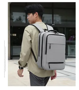 Side view of a grey multi-layer business laptop backpack worn by a man in a city setting