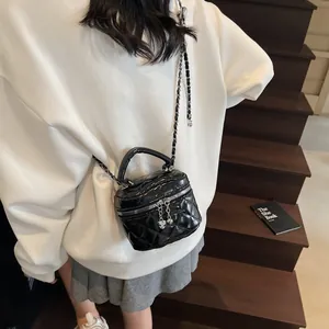 Mini sac boîte noir matelassé avec fermeture cœur et chaîne porté par un mannequin