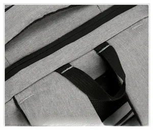Detail showing reinforced bar-tack stitching and durable fabric on grey laptop backpack