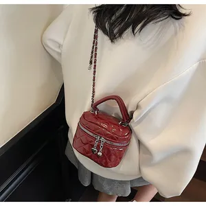 Détail du mini sac bandoulière matelassé en cuir verni bordeaux avec cœurs
