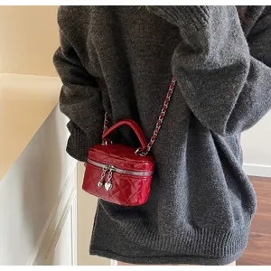 Détail du sac boîte matelassé rouge avec zip cœur et bandoulière chaîne argent