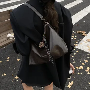 Sac hobo vintage en cuir marron avec charme raquette de tennis pour mode de rue décontractée