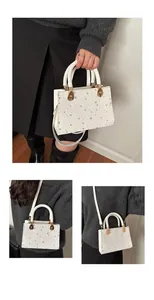 Detail van witte tas met zilveren sterren, geweven handvatten en gouden accessoires