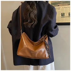 Détail du sac hobo marron vintage avec étiquette mode et accessoire foulard rayé